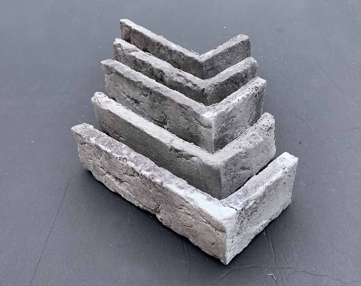 Renewed Antique Brick 2919. Thin Brick Veneer in Varying Shades of Gray. Time-Weathered Surface with Distressed Corners. Half-Inch in Thickness.