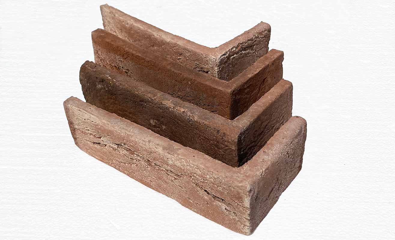 Aura Brick 1005. Earthy Toned Thin Brick Veneer with Peach Background. Half-Inch Thickness. Handcrafted Appearance with Worn Corners.